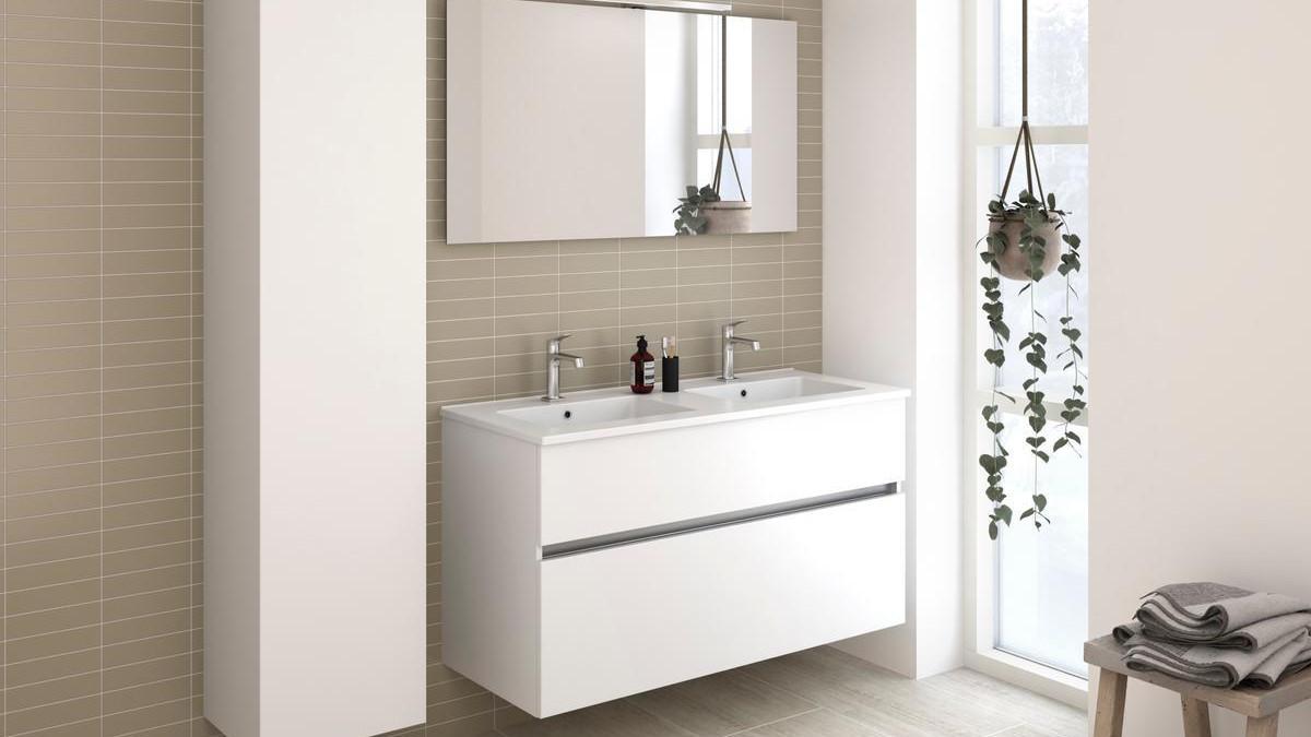 Moderne baderom med hvit servant, speil og planter i vinduet, samt beige fliser på veggen.