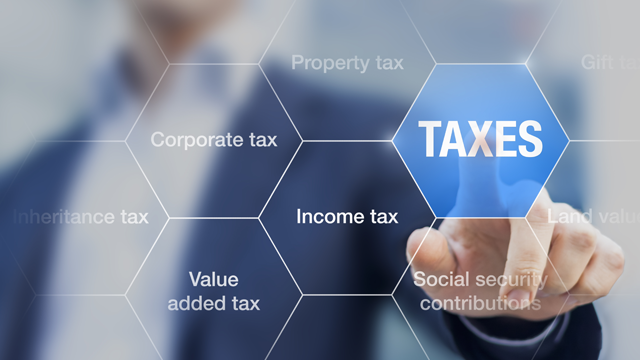 En person peker på en hexagon med teksten "TAXES", omringet av ulike skatter som inntektsskatt og eiendomsskatt.