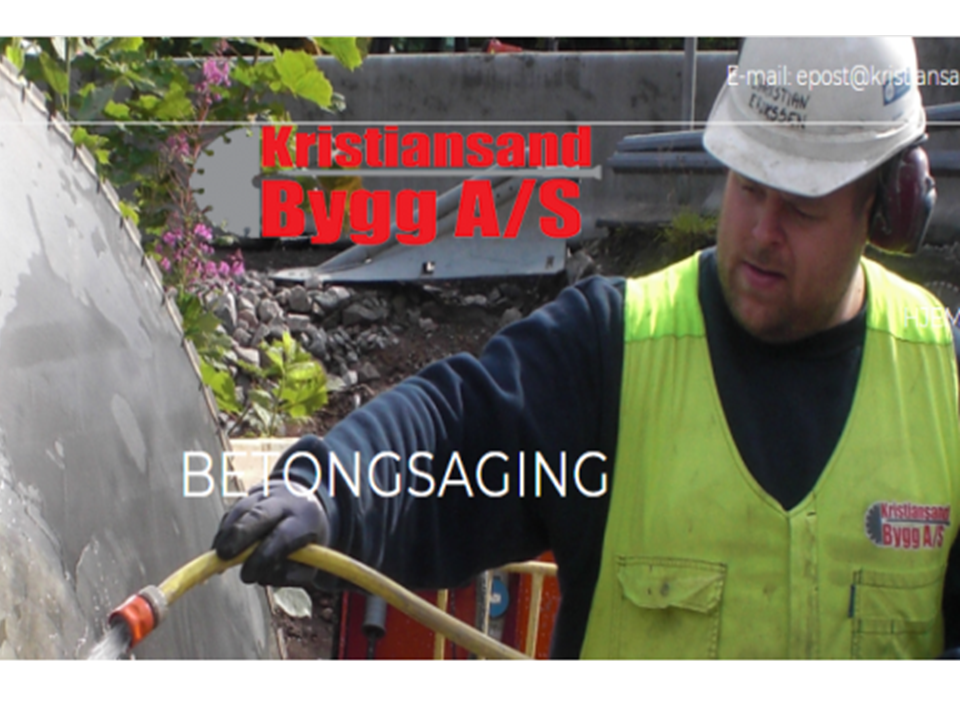 En arbeidstaker i sikkerhetsvest sprayer vann på en betongoverflate på en byggeplass.