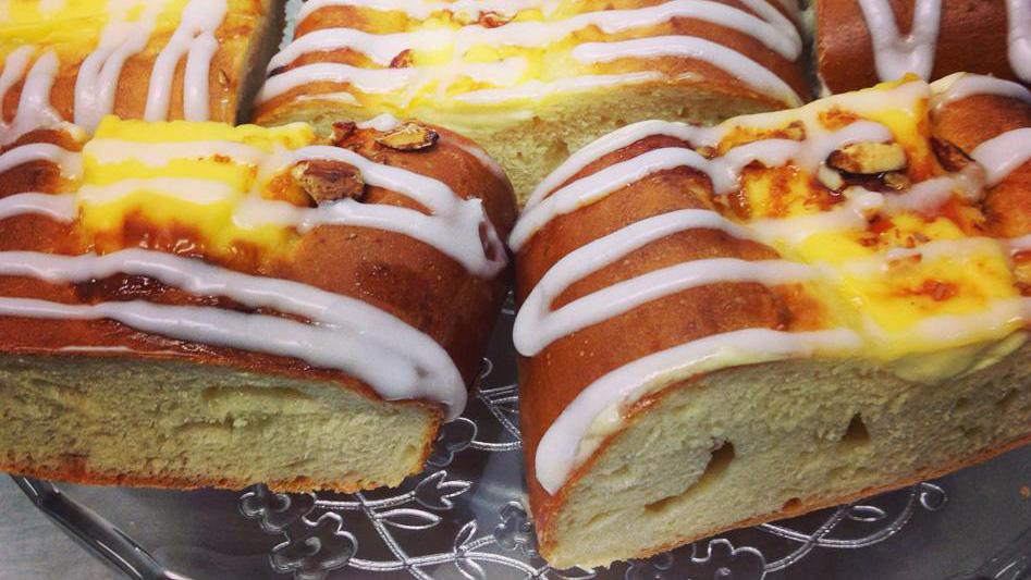 Saftig kake med glasur og fyll av vaniljekrem, servert på en dekorativ tallerken.