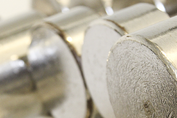Nærbilde av metallvekter stablet i en rekke, med fokus på de glatte overflatene.