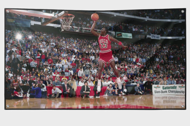 Michael Jordan utfører en spektakulær dunk under Slam Dunk Championship foran et entusiastisk publikum.