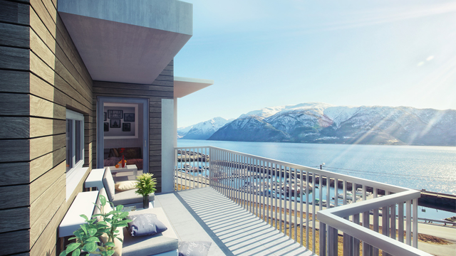 Moderne balkong med utsikt over fjorden og snødekte fjell i bakgrunnen, med sitteplasser og planter.