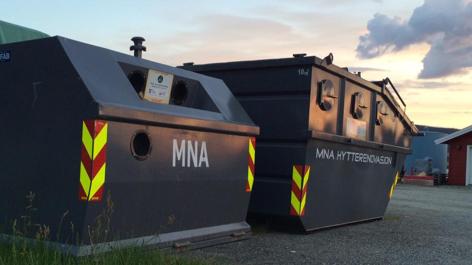 To containere for avfall med refleksbånd, plassert på en grusvei under en solfylt himmel.