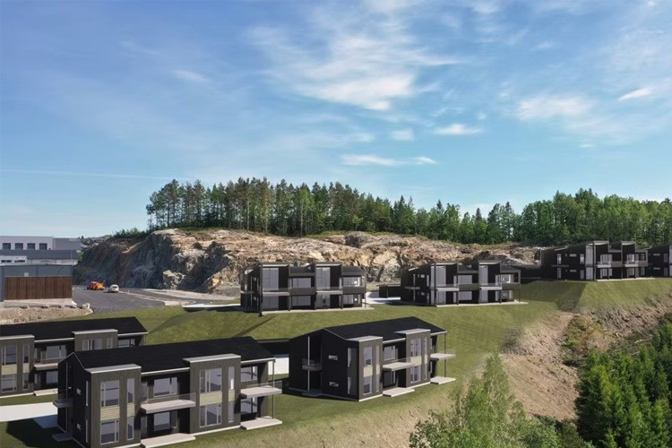 Moderne boliger i svart med grønt landskap og skog i bakgrunnen, plassert på en skråning.