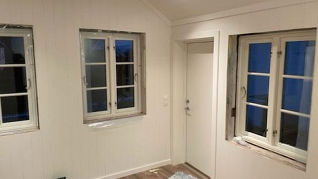 Lys og moderne rom med hvite vegger, vinduer og en dør, klar for innredning.