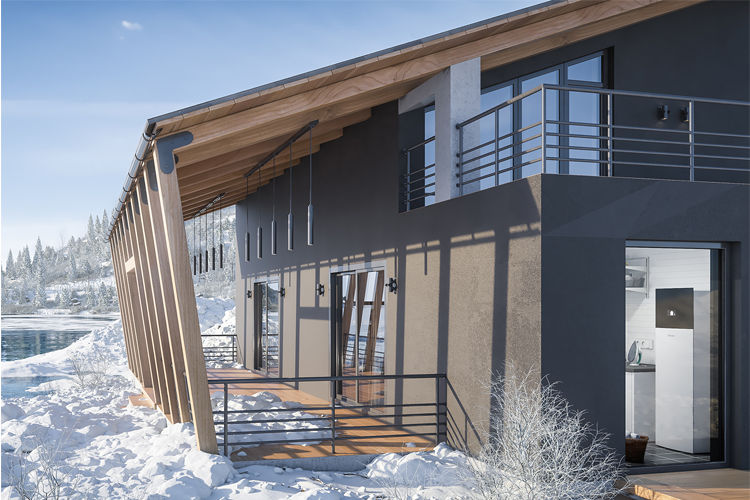 Moderne hus med skråtak og store vinduer, omgitt av snø og natur, ved vannkanten.