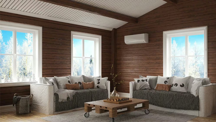 Moderne stue med to sofaer, et trebord og store vinduer som viser snødekte trær utenfor.
