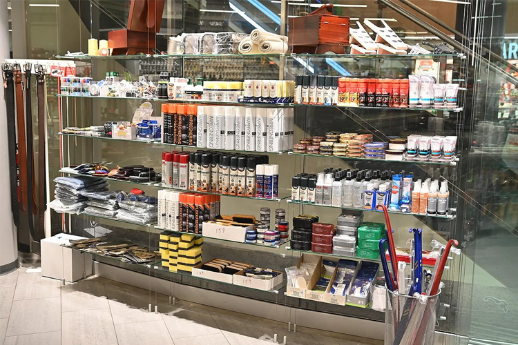 Hylla med ulike produkter som hudpleie, hårpleie og kosmetikk i en butikk.