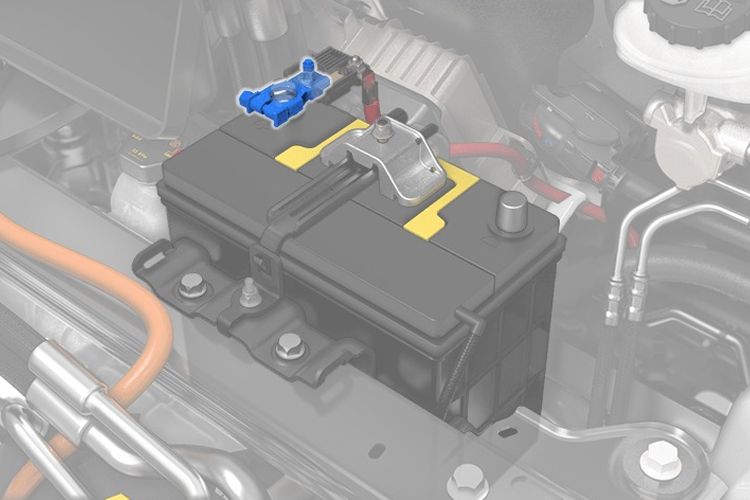 Batteri i motorrommet med tilkoblinger og ledninger synlige.