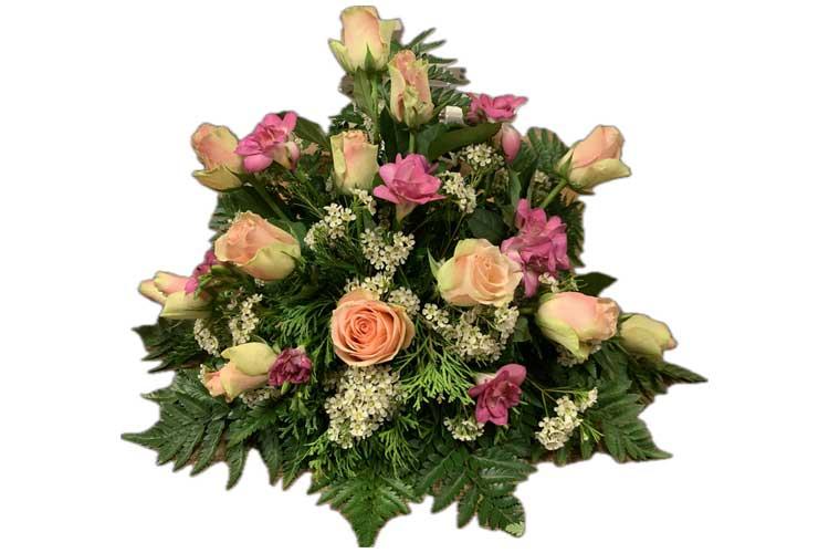 En vakker blomsteroppsats med rosa roser, nelliker og grønt bladverk.