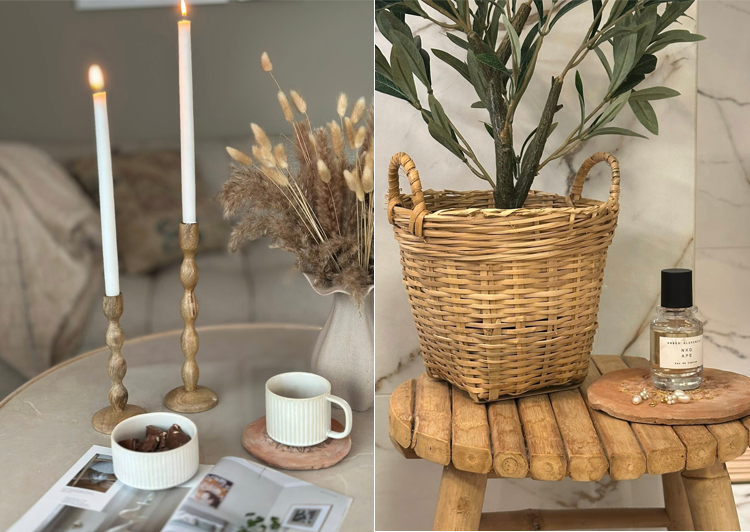 Interiør med stearinlys, en kurv med planter, kaffekopper og en parfymeflaske på et trebord.