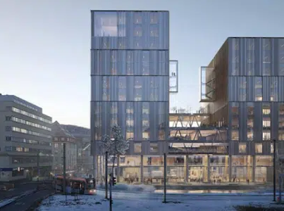 Moderne kontorbygg med glassfasade og snødekt gate i forgrunnen, omringet av bylandskap.