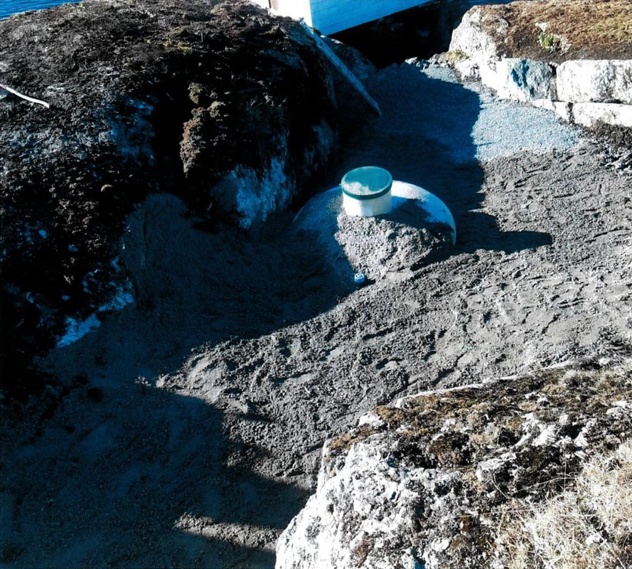 Bilde av en gruslagt område med en hvit plastskål og steiner ved vannkanten.