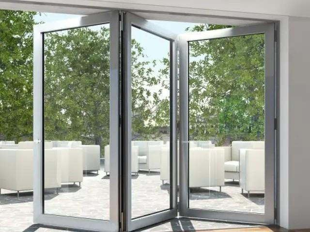 Åpne glassdører som fører ut til en terrasse med hvite møbler og grønne trær i bakgrunnen.