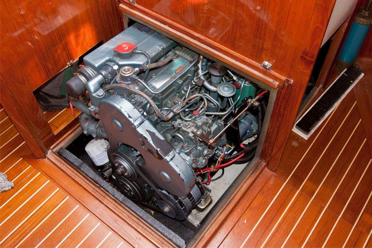 Båtens motor synlig i motorrommet, med detaljerte ledninger og komponenter på en tredekket båt.
