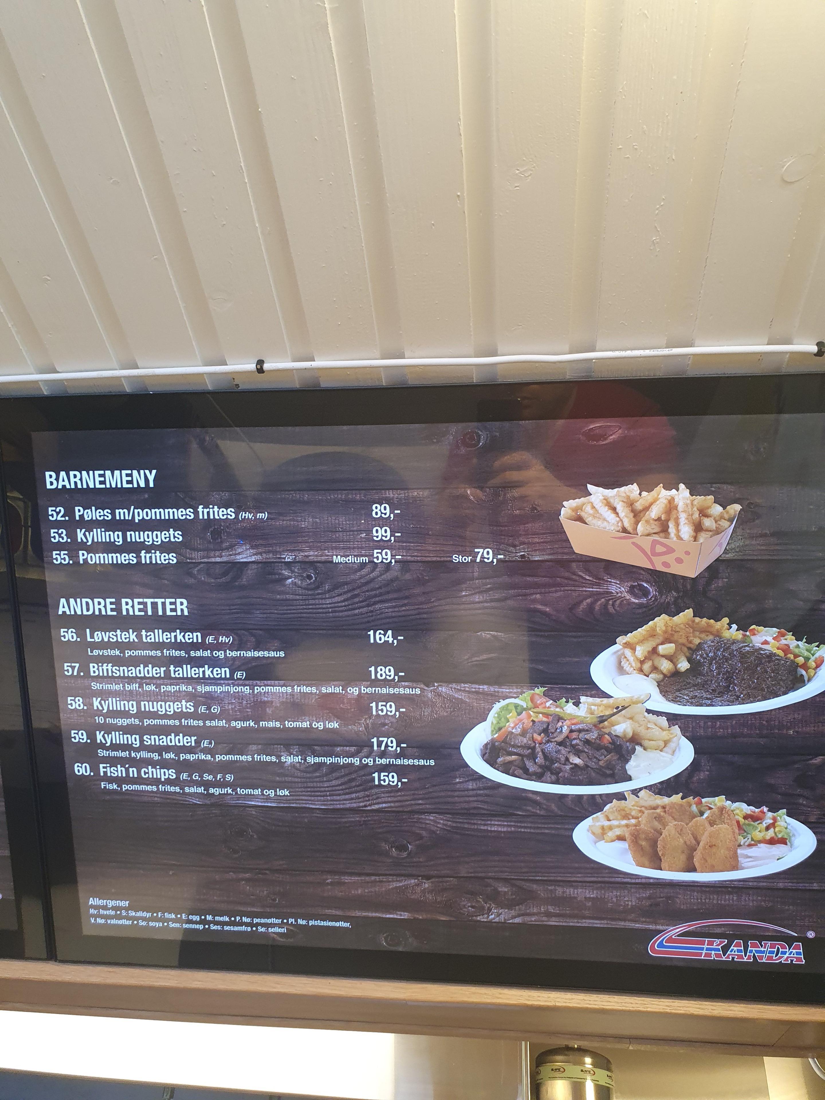 Meny med barnemeny og andre retter, inkludert pommes frites, kylling og biff, på en skjerm.