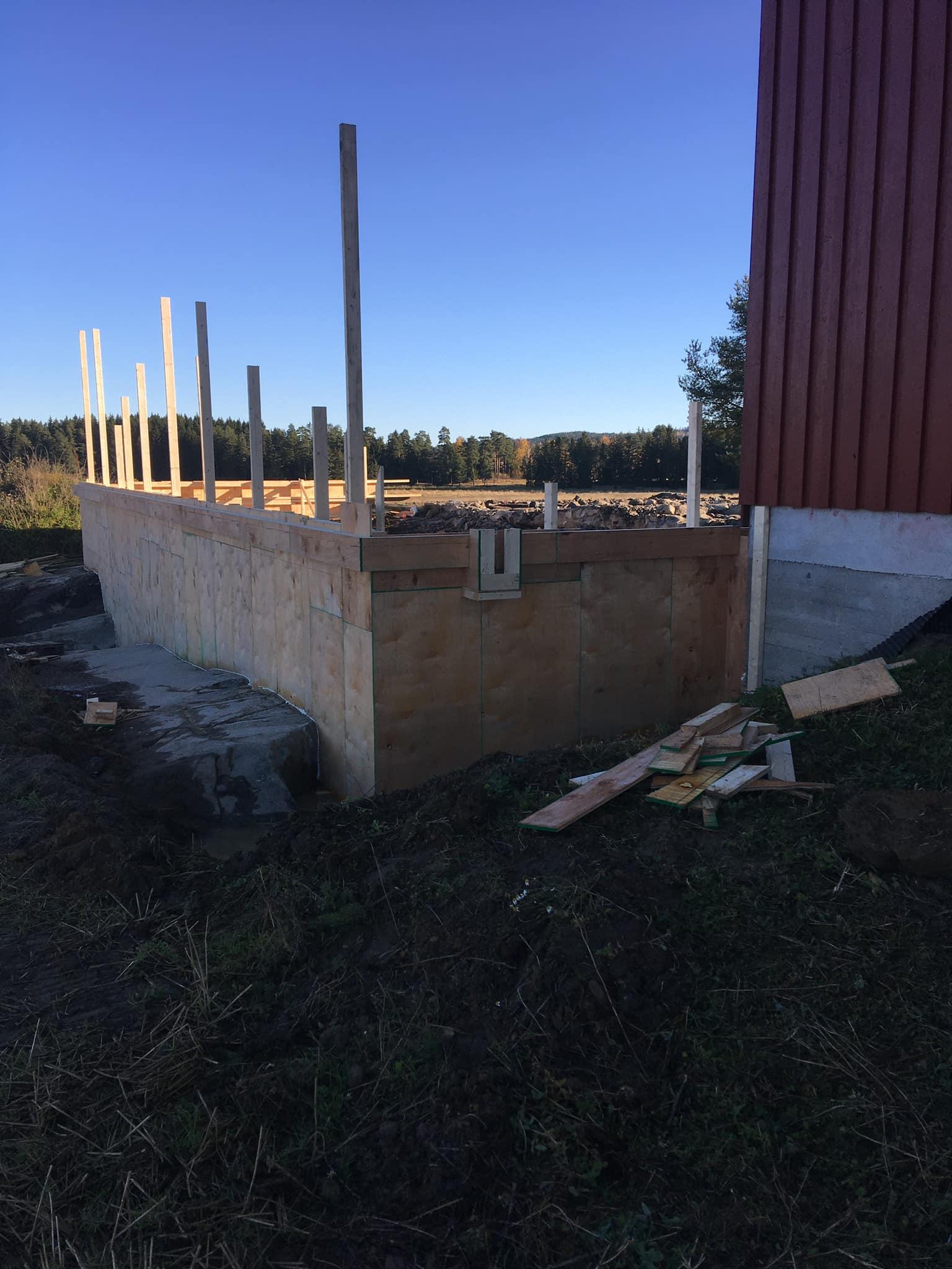 Fundamentet til en bygning med stendere, plassert på en byggeplass om dagen.