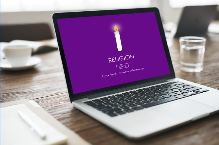 En bærbar datamaskin med en skjerm som viser teksten "RELIGION" på lilla bakgrunn.