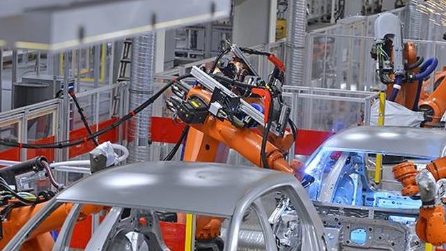Industrielle roboter monterer biler i en moderne bilfabrikk med automatiserte prosesser.