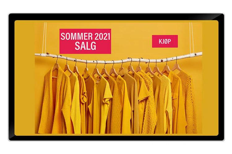 Gul sommerklær med salgsskilt for 2021 hengende på en klesstang mot en gul bakgrunn.