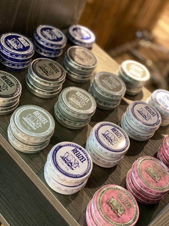 Bokser med forskjellige typer snus i ulike farger og størrelser på en hylle.