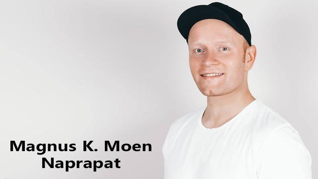 En smilende mann med kort hår iført en svart caps og hvit t-skjorte, står foran en lys bakgrunn.
