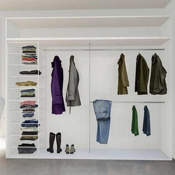Moderne garderobe med klær som jakker, bukser og skjorter, samt sko på gulvet.