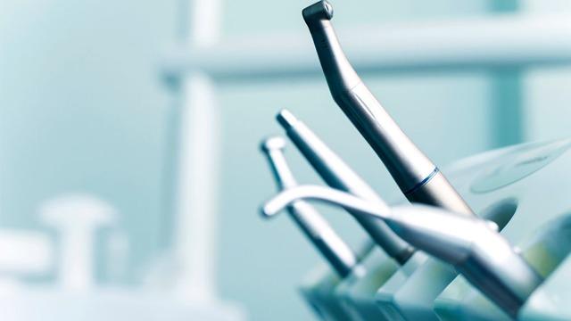 Tannlegeverktøy i en moderne tannlegeklinikk, med fokus på metalliske instrumenter.