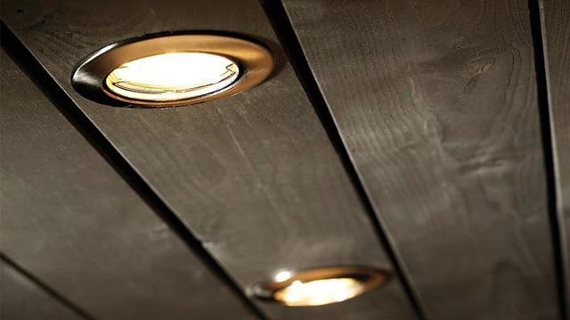 To taklamper i et mørkt trepanel, som gir et varmt lys til rommet.