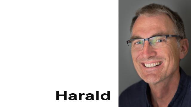 En smilende mann med briller, kort grått hår og en blå skjorte, med navnet "Harald" skrevet under.