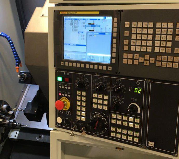 Kontrollpanelet til en CNC-maskin med skjerm og mange knapper og brytere.