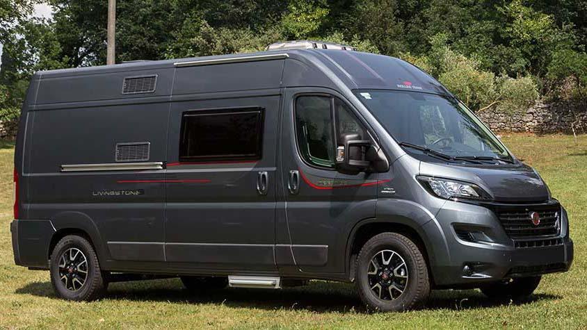 En grå campingbil parkert på gresset, med moderne design og store vinduer.
