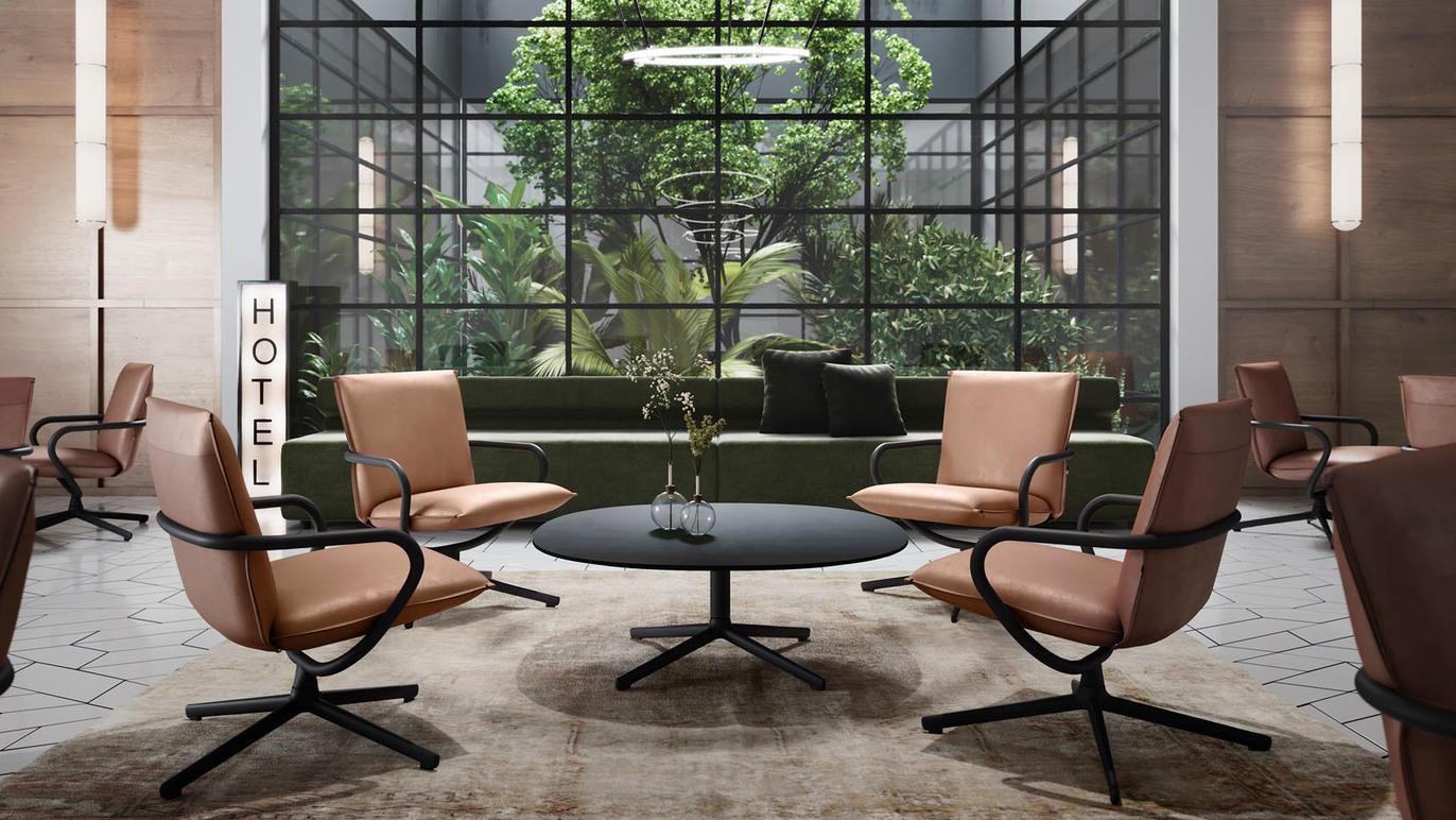 Moderne hotellobby med brune stoler, svart bord og store vinduer som viser en grønn plante.