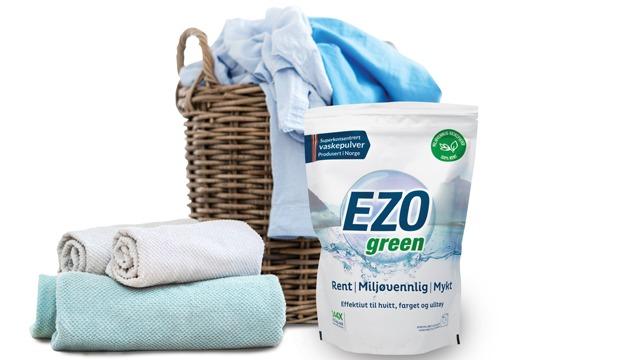 EZO green vaskemiddelpose med håndklær og en kurv med klær i bakgrunnen.