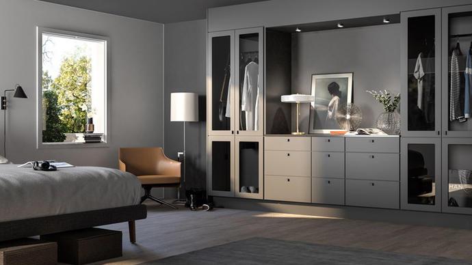 Moderne soverom med en seng, garderobeskap, lampe og en stol, med naturlig lys som strømmer inn fra vinduet.