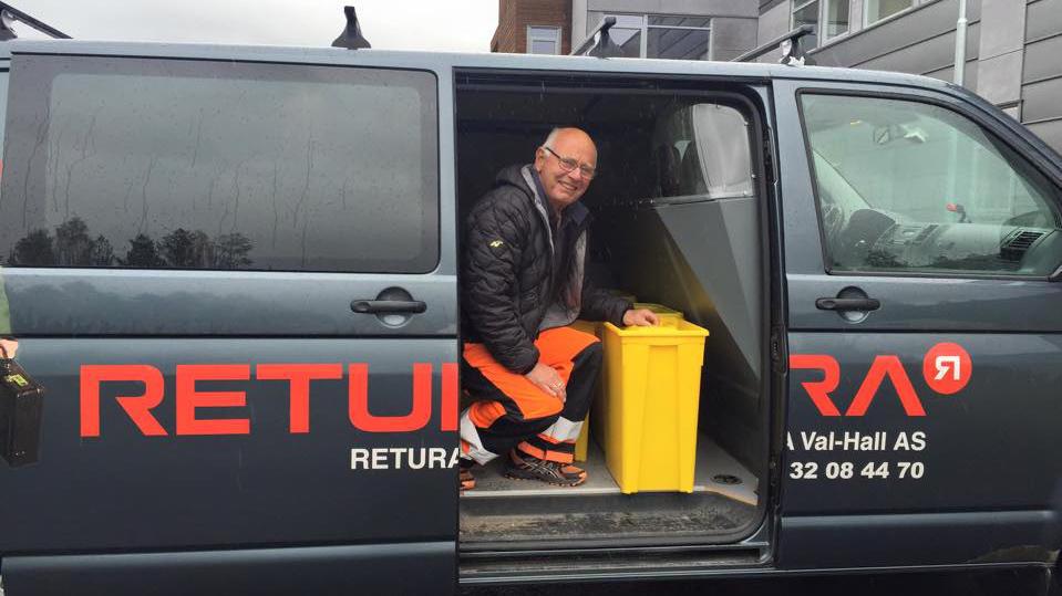 Mann i arbeidsklær sitter i en varebil med en gul søppelbøtte, med logoen til Retura synlig på siden.