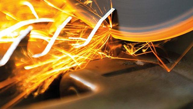 Sparks fly from a metal cutting tool, showcasing the precision and intensity of the machining process.