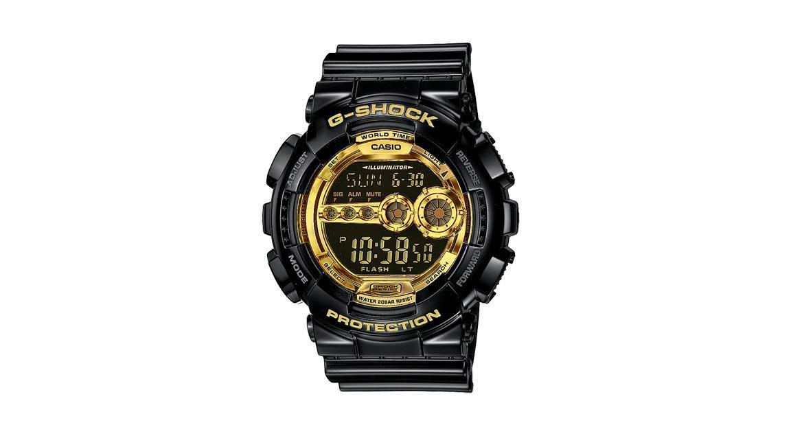 G-SHOCK klokke med svart rem og gullfarget urskive, digitalt display og beskyttelsesfunksjoner.