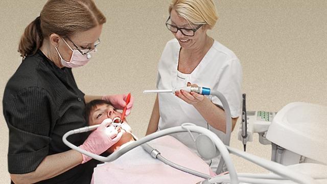 To tannleger som behandler en pasient i en moderne tannlegeklinikk.