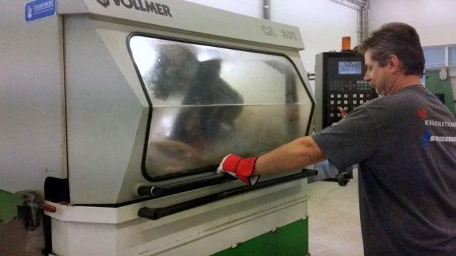 En mann bruker en Vollmer maskin i en verksted, med fokus på presisjonsarbeid og industriell produksjon.