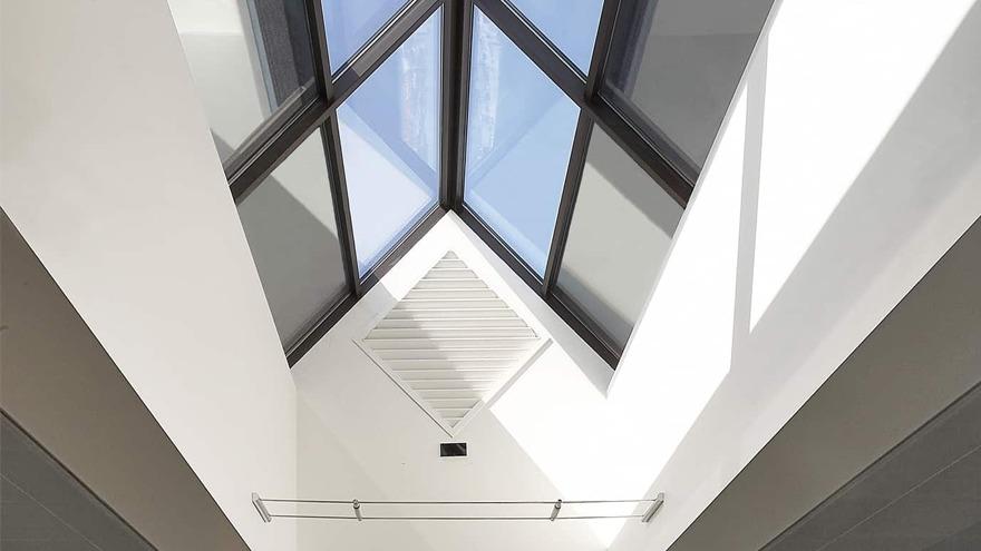Lys og moderne takvindu i en romslig gang med hvite vegger og minimalistisk design.