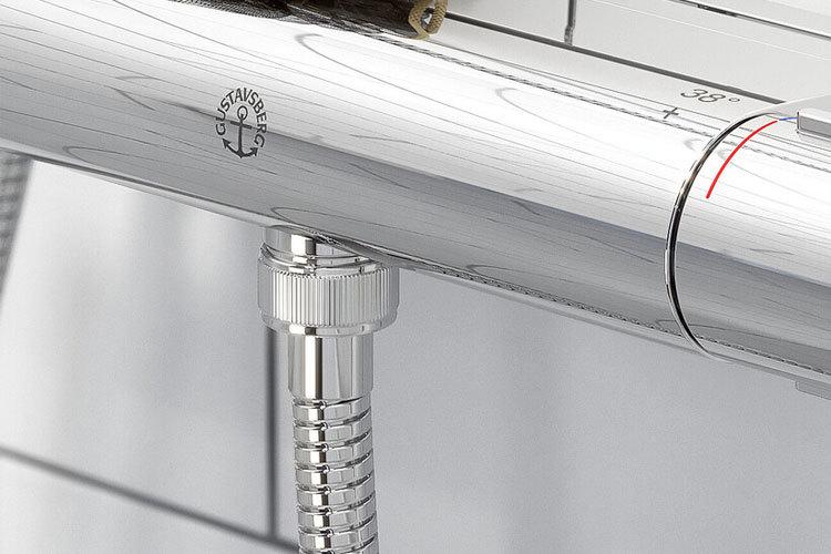 Krommet blandebatteri med synlige rør og detaljer i moderne design på et bad.