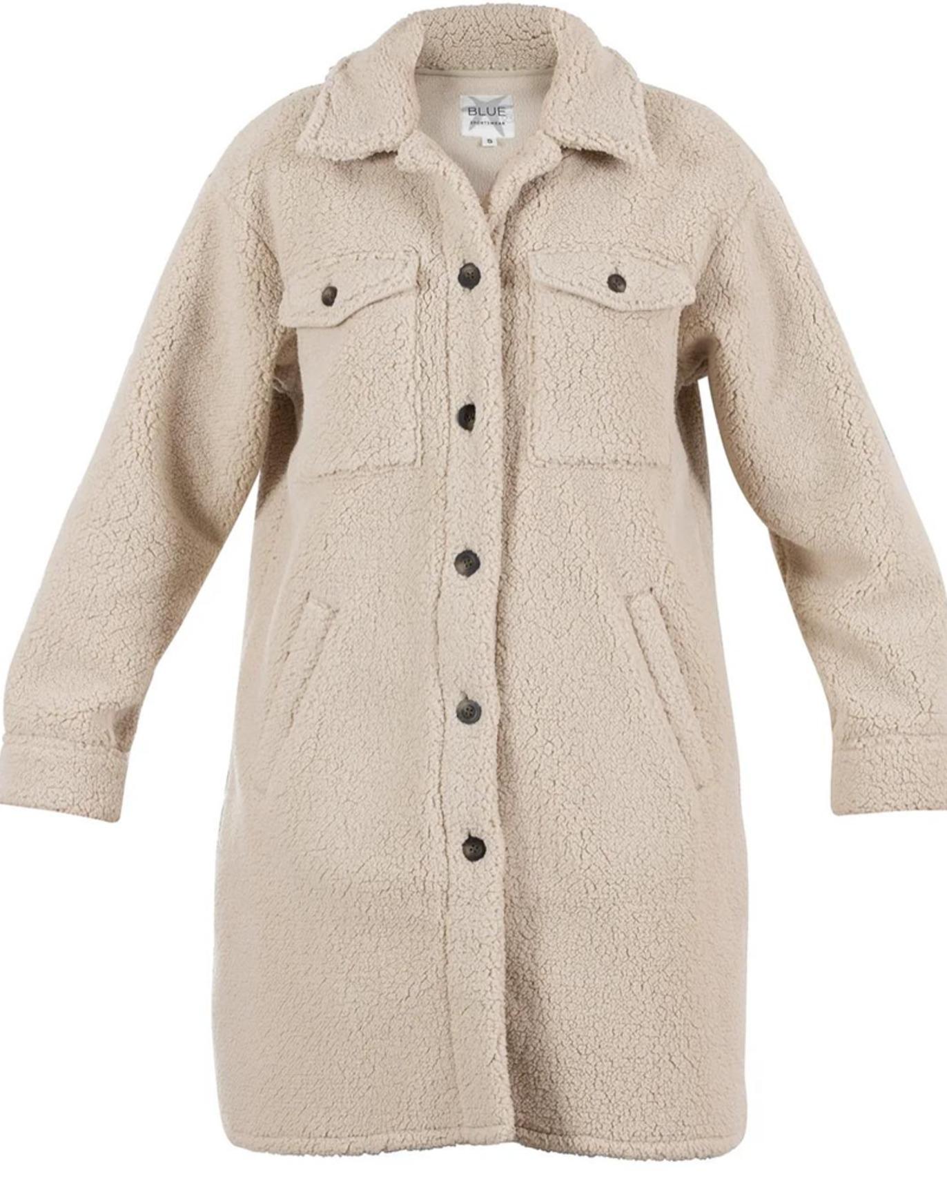 En beige teddyjakke med knapper, lommer og krage, perfekt for høst- og vinterbruk.