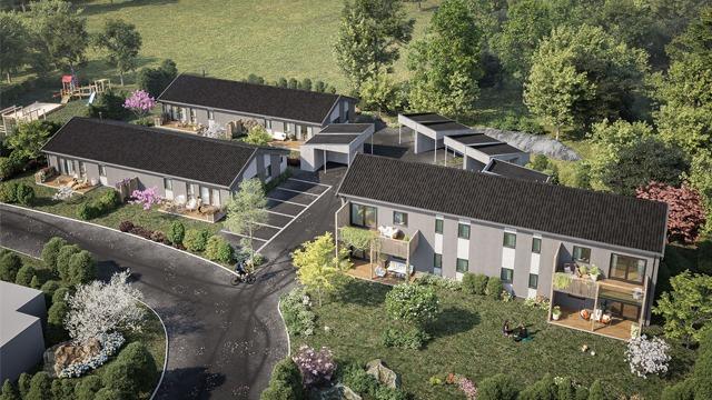 Moderne boliger med hager og parkeringsplasser, omgitt av trær og grøntområder.
