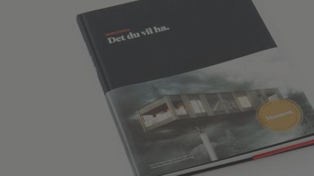 Bok med tittelen "Det du vil ha" på omslaget, med moderne design og bilder av en bygning.