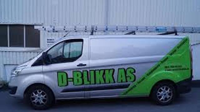 En sølvfarget varebil med grønn logo for D-BLIKK AS, parkert foran en bygning.