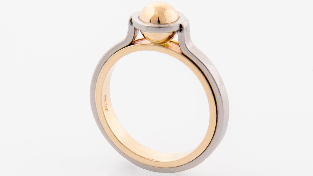 En elegant ring med en gullkule og en sølvfarget ramme, perfekt for spesielle anledninger.