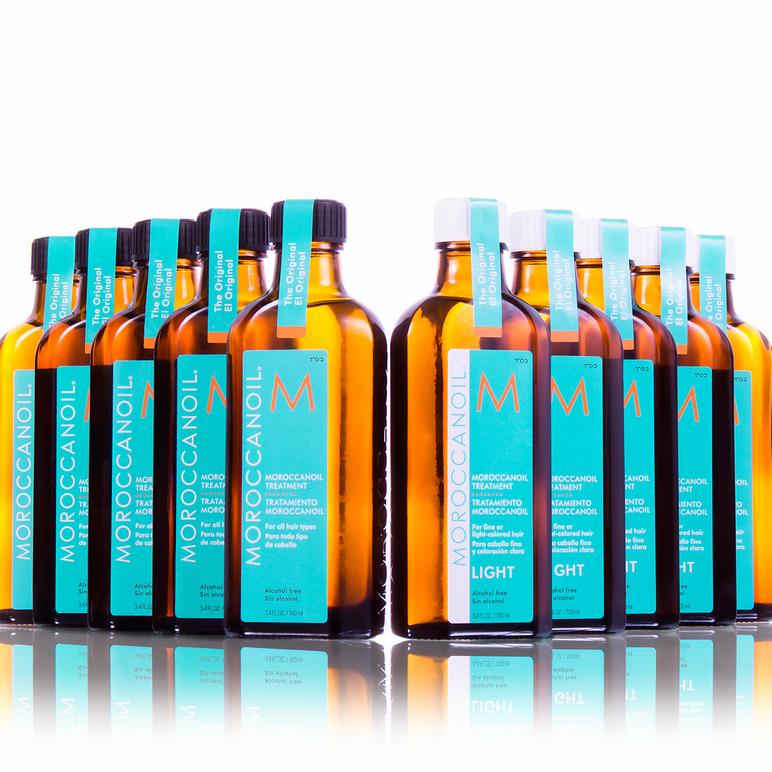Flere flasker med Moroccanoil hårprodukter i forskjellige varianter, plassert på en hvit bakgrunn.