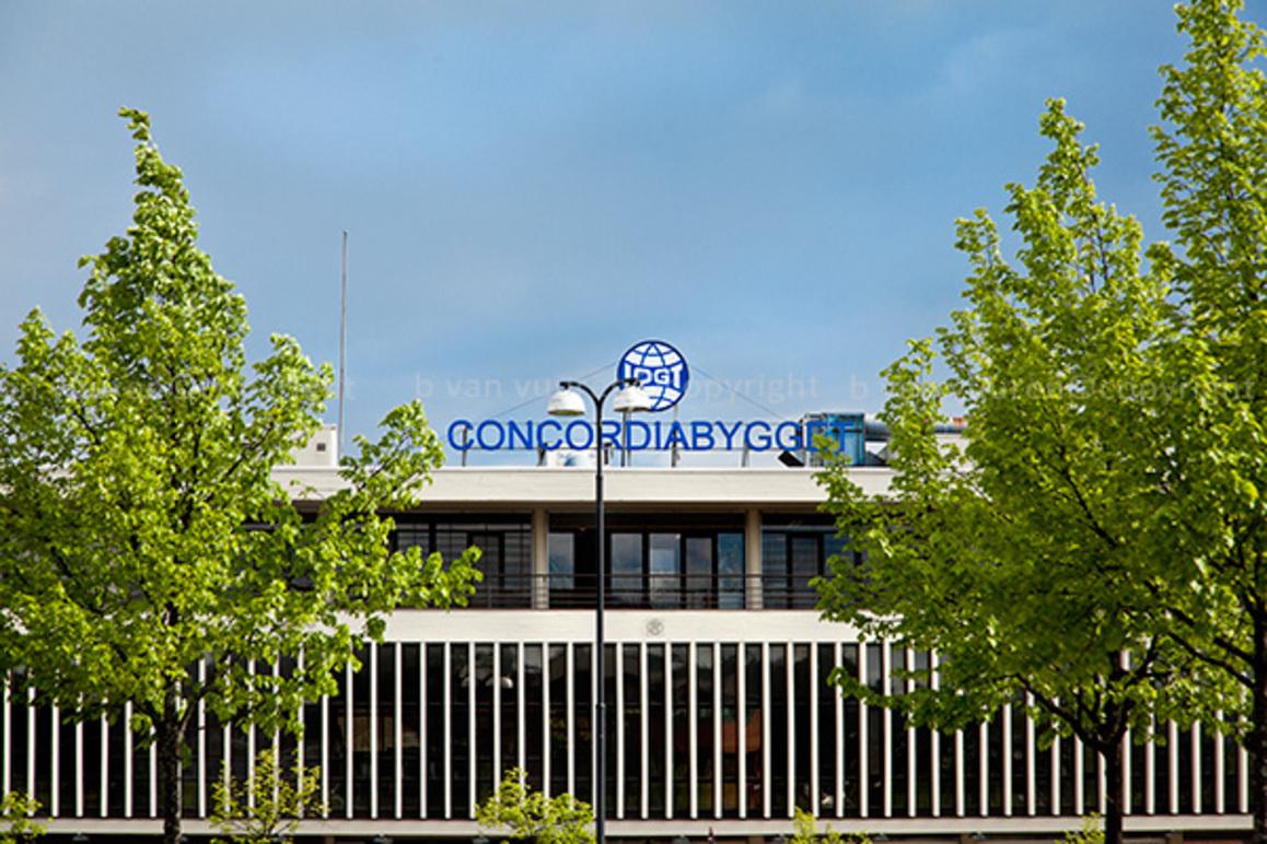 Bygningen til Concordiabygg med grønne trær foran og blå himmel i bakgrunnen.